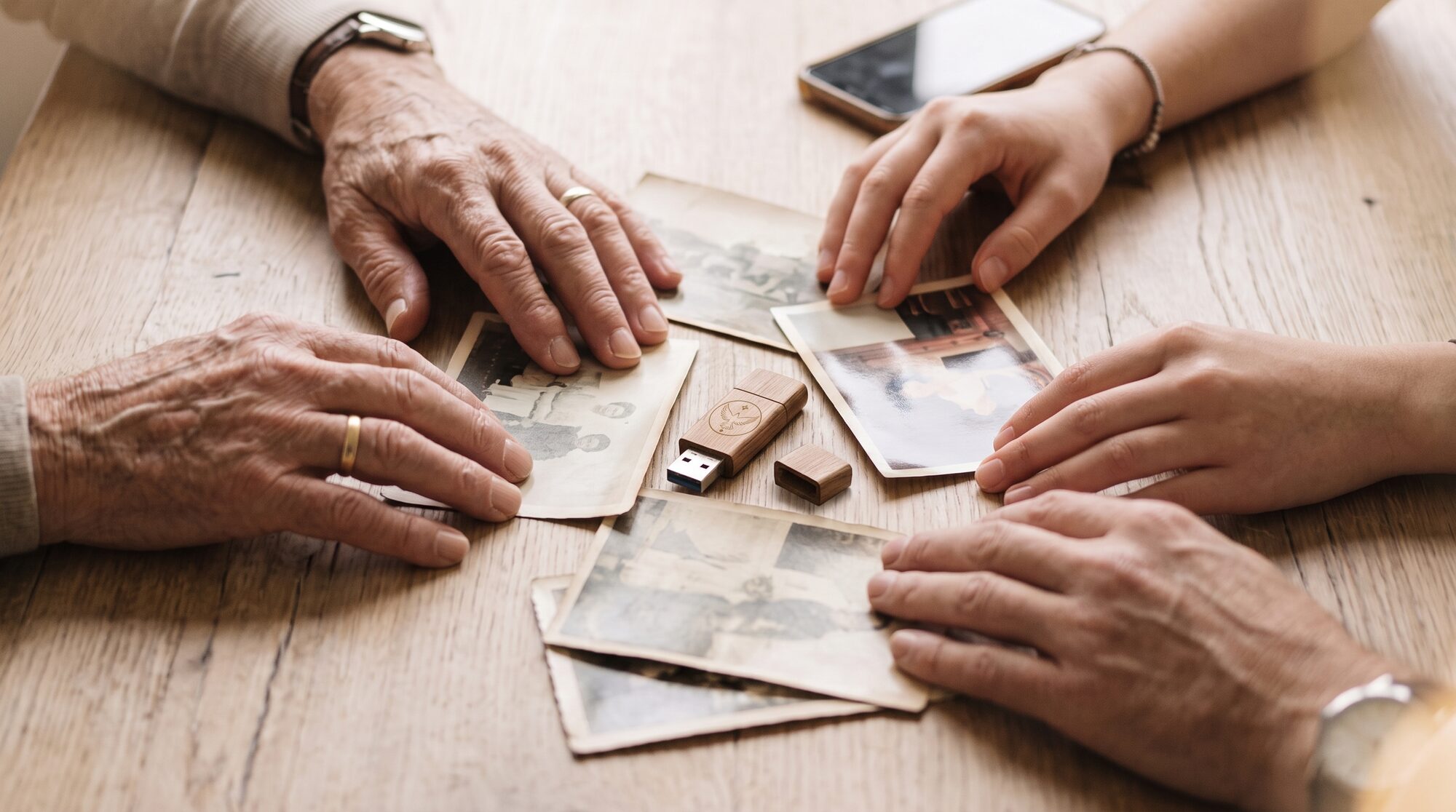 Une famille réunit des photos anciennes et une clé USB Legacy Love autour de la table